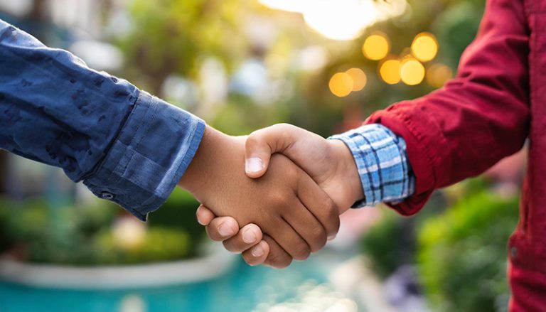 Un bambino con disturbo pragmatico della comunicazione stringe la mano a un uomo in segno di amicizia